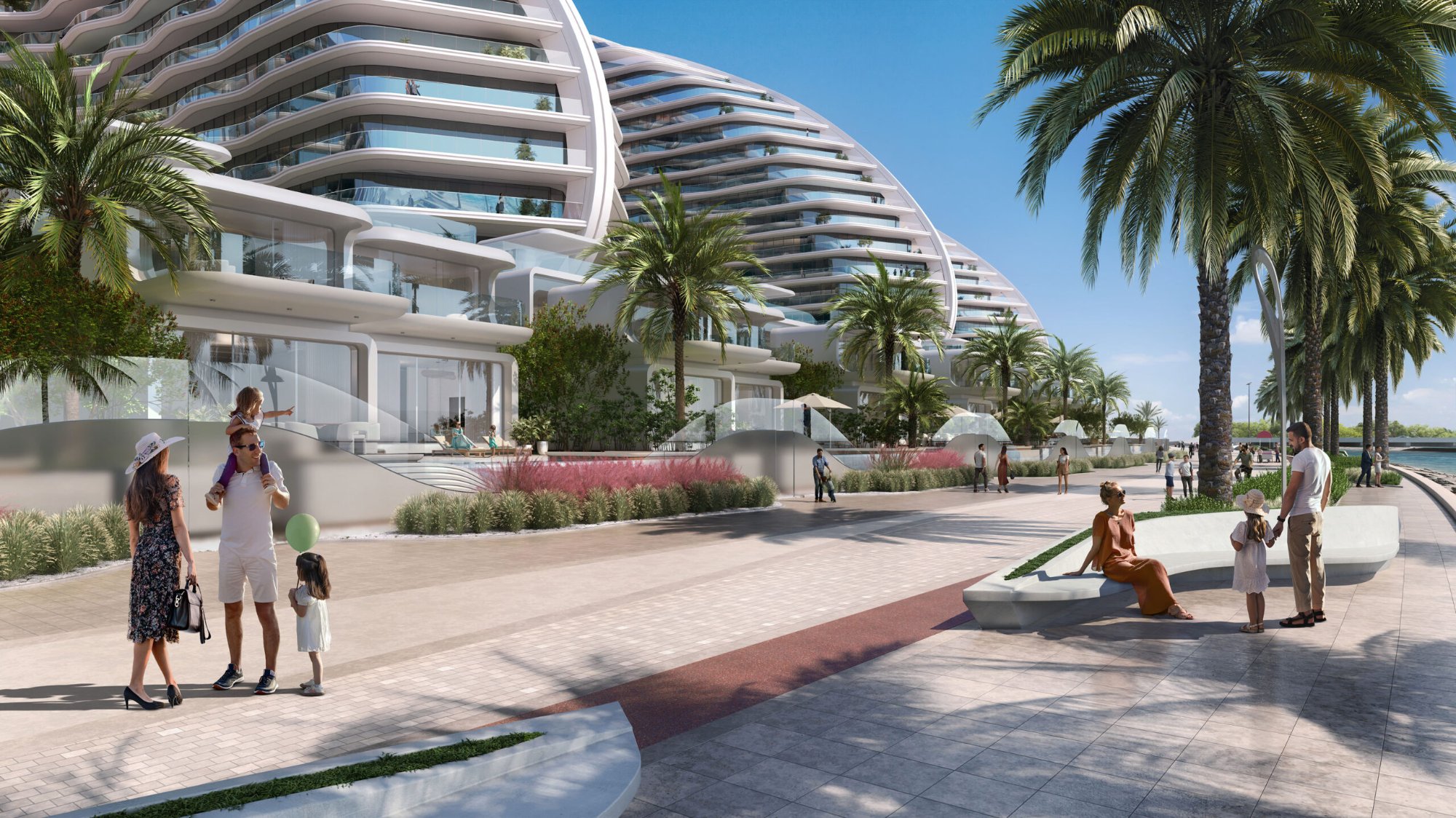 Oystra promenade level — families on the landscaped waterfront promenade with the organic ZHA tower facades rising above palm trees
