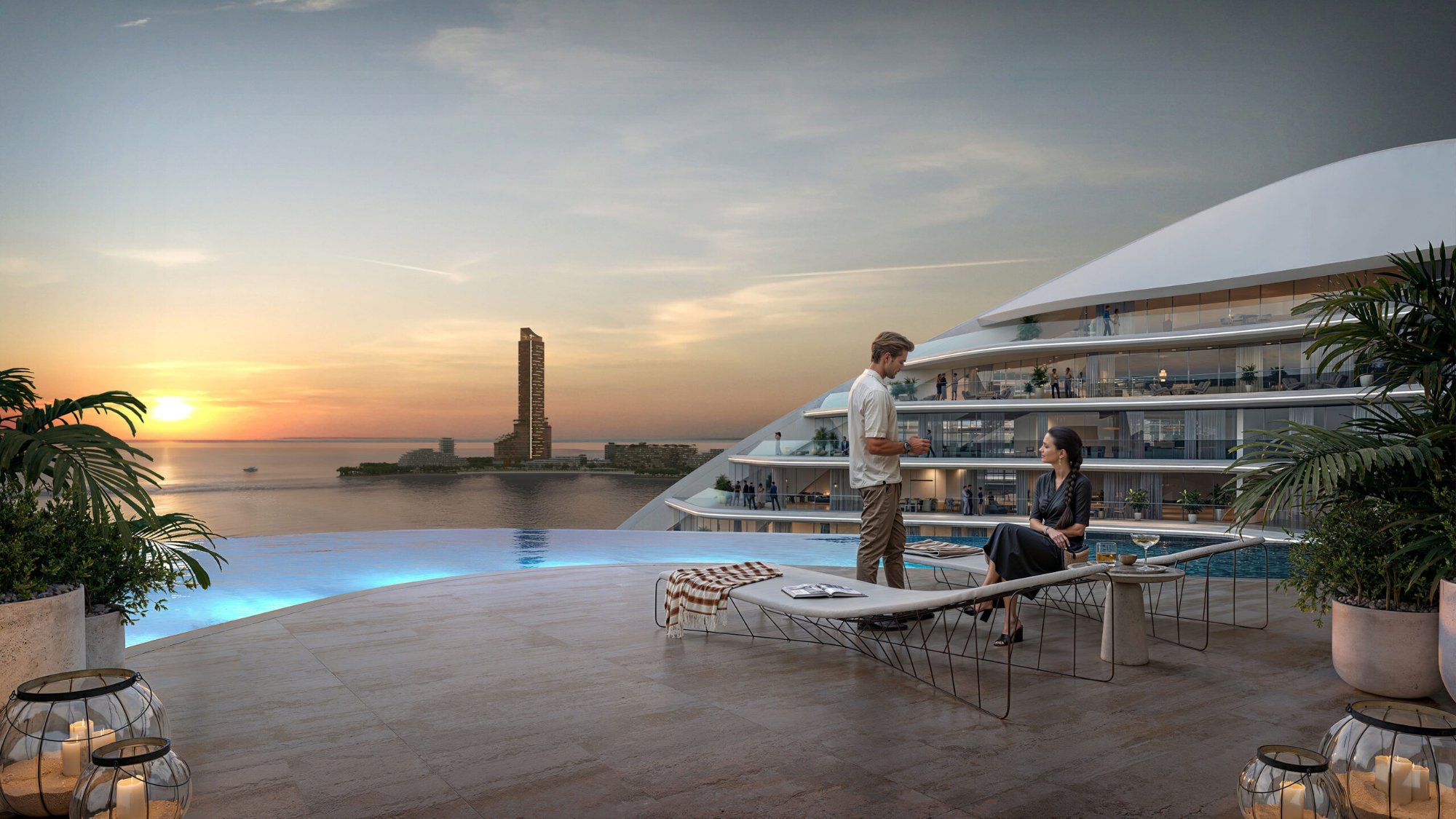 Oystra sunset pool — couple at infinity pool with Wynn Al Marjan Island tower glowing on the horizon at golden hour