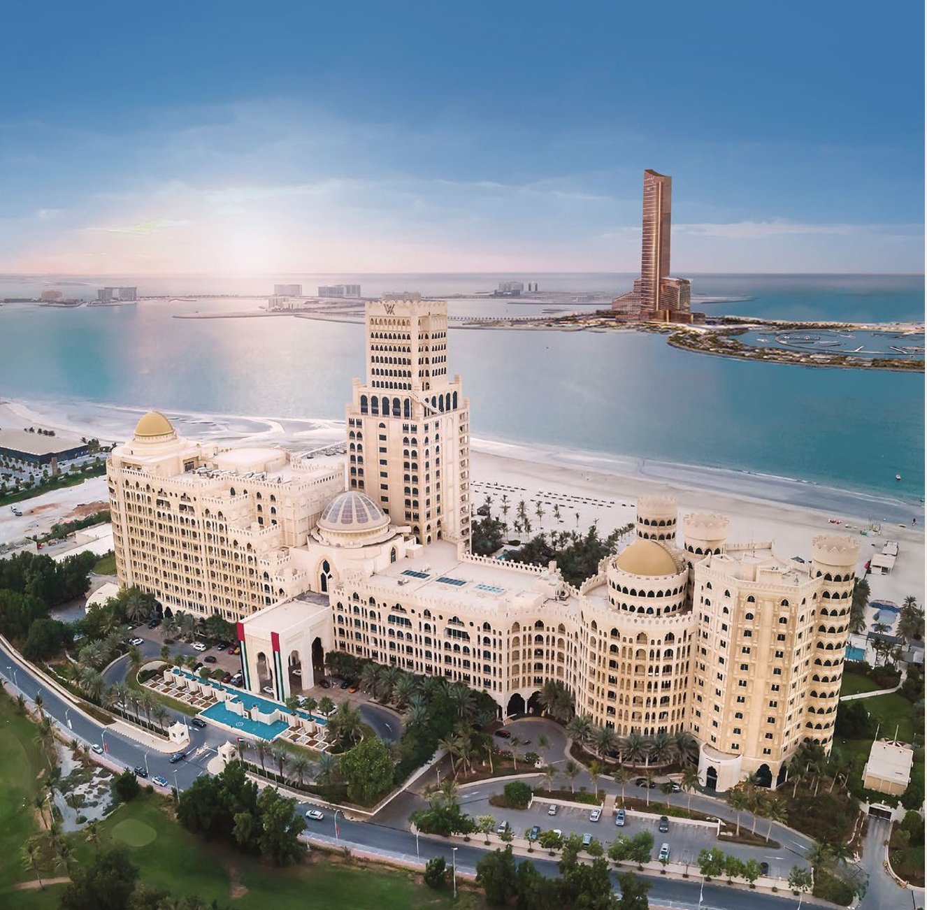 Waldorf Astoria Ras Al Khaimah aerial view with Wynn Al Marjan Island tower visible on the horizon — the two most prestigious landmarks in RAK